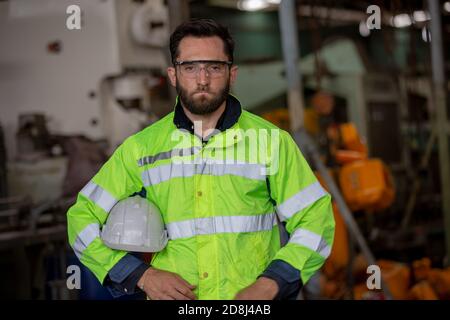 Portrait of female Engineer standing with confident against machine environment in factory, Engineers operating a machine in factory Stock Photo