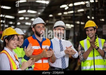 Male Industrial Engineers Talk with Factory Worker . They Work at the Heavy Industry Manufacturing Facility. Stock Photo