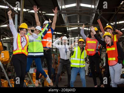 Group of Engineer manager and Factory Workers Team standing against production line. Stock Photo