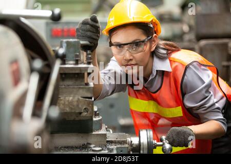 Female Engineers operating a cnc machine in factory Stock Photo