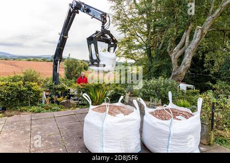 Big bags of gravel being delivered by a lorry crane to a domestic property in the village of Irthington, Cumbria UK