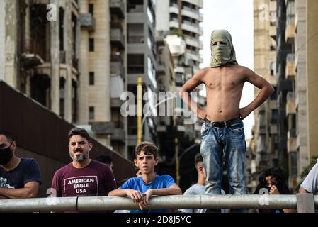 Beirut, Lebanon, 30 October 2020. Onlookers watch as a small group of men from Tripoli and Beirut clash with Lebanese Interior Security Forces during an attempt by pan-islamic group Hizb Ut Tahrir to march to the French Embassy in protest of what they view as president Emmanuel Macron's anti-islamic stance. Emotions ran high as it was felt the Prophet Mohammed is being disrespected during his birthday month. Credit: Elizabeth Fitt/Alamy Live News Stock Photo