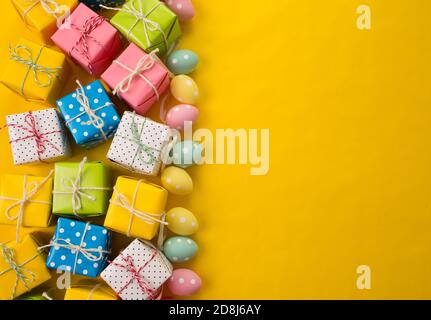 lots of gifts Easter eggs on a yellow background Stock Photo