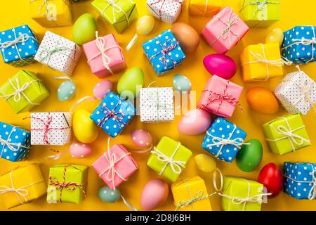 lots of gifts Easter eggs on a yellow background Stock Photo