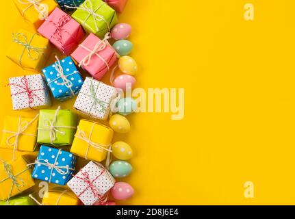 lots of gifts Easter eggs on a yellow background Stock Photo