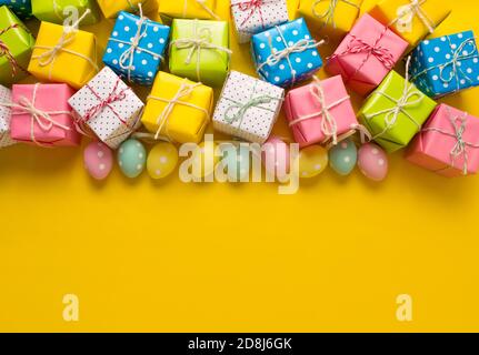 lots of gifts Easter eggs on a yellow background Stock Photo