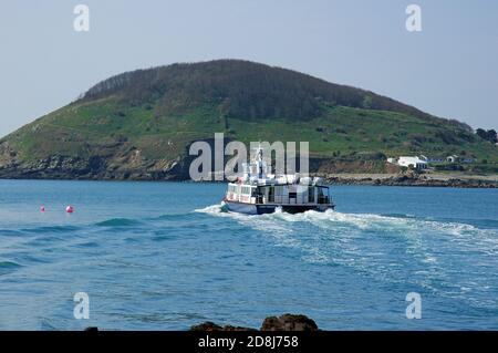 Ferry leaving Herm Island, approaching Jethou Island on its way back to St Peter Port, Guernsey, Channel Islands, April. Stock Photo