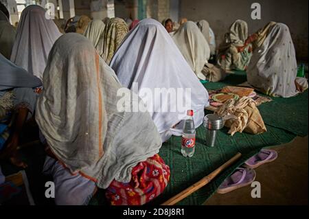 Vrindavan, India, August 2009. Widows praying inside an ashram. Stock Photo