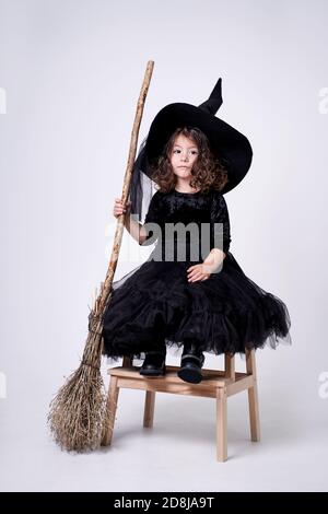 funny witch girl on white background with broom Stock Photo