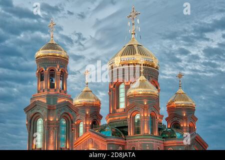 = Illuminated Domes of the Resurrection Cathedral in Twilight =  Shining gold domes (cupolas) of the Resurrection Cathedral, the Main Church of the Ru Stock Photo