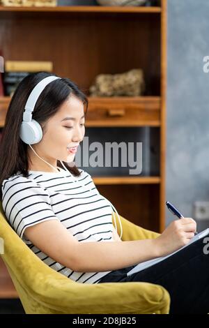 Asian Woman writing in notebook, planning day in diary. Beautiful business female Stock Photo