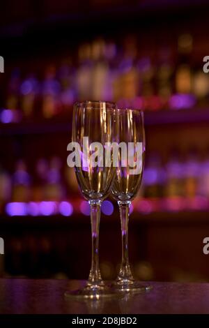 Two wine glasses filled with purple filled background lights and gleam of glass. Stock Photo