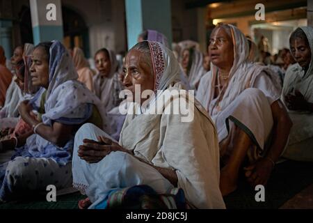 Vrindavan, India, August 2009. Widows gathered to pray inside an ashram. Stock Photo