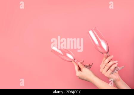 Two glasses in the hands of a woman on pink, with space for copying. Stock Photo