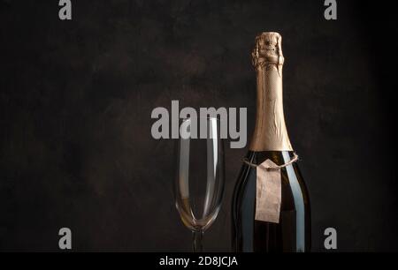A bottle of alcohol and a wine glass on a brown background with space for copying. Stock Photo