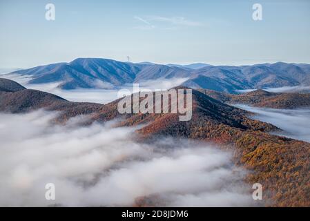 Devil's Knob Overlook at Wintergreen resort town with Blue Ridge parkway road highway in mountains with autumn fall clouds mist fog covering peak high