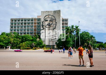 Tourists photograph the image of Che Guevara on the front of the Ministry of Interior building in Revolution Square. La Habana - La Havana, Cuba, Lati Stock Photo