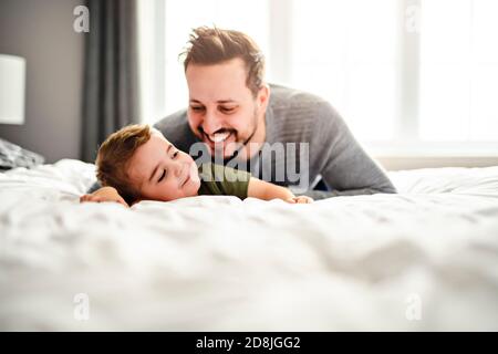 A Father and son on bed playing Portrait of happy child Stock Photo