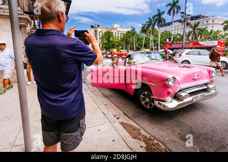 Tourist takes pictures of a vintage taxi near Central Park - Almendrón - near Central Park - Parque Central. Havana. Cuba, Latin America and the Carib Stock Photo