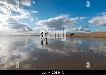 people-walk-away-from-the-beach-wrapped-in-towels-after-completing-the