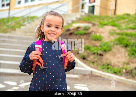 A nice Portrait of cute hispanic girl with backpack at school Stock Photo