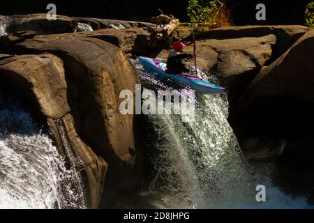 Ohiopyle Falls, PA, USA 10/01/2017: A kayaker wearing a red helmet with camera attached to it is doing a brave performance by descending down the fast Stock Photo