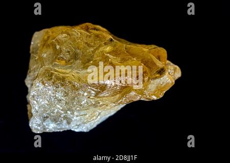 Natural citrine quartz, yellow stone  on a black background. The lighting used creates the illusion of a dog's head Stock Photo