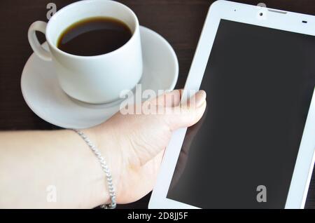 empty tablet and a cup of coffee on the black desk Stock Photo