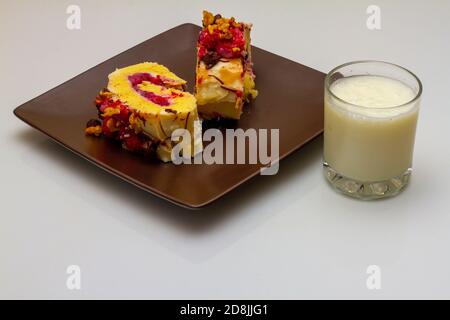 Close up image showing two thick slices of home made swiss roll cake filled with tasty fresh berries and finished with vanilla icing cream berry walnu Stock Photo