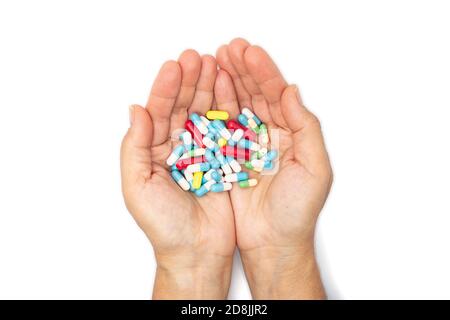 A handful of colored pills in the hands Stock Photo