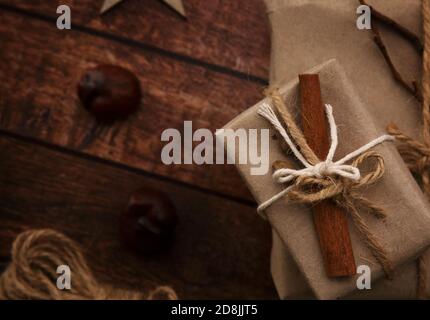 box with a gift, chestnuts and rope on a wooden table Stock Photo