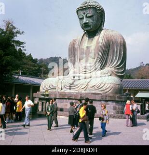 1960s, historical, visitors at the Buddhist temple at Kotoku-In, Kamakura, Kanagawa, Japan, home of the Daibutsu or Great Buddha, a giant Bronze statue and one of the country's most visited tourist attractions. The statue dates back to the 13th century and is the second tallest bronze Buddha in Japan. Stock Photo