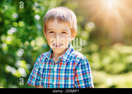 Happy child smiling outdoors on sunny day Stock Photo