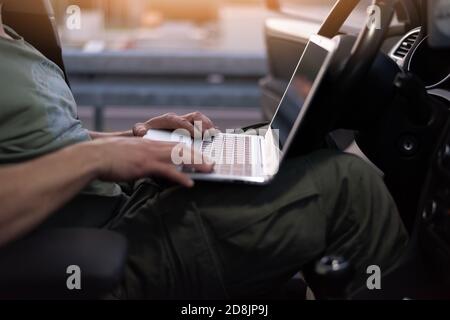 Mobile car service engineer checking car with his laptop on the road. Road assistance concept Stock Photo