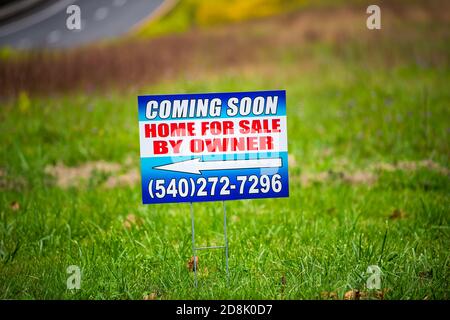 Washington, USA - October 27, 2020: Coming Soon home for sale by owner front yard lawn sign with phone number in in Virginia countryside rural farm in Stock Photo