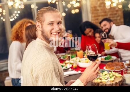Happy man looking at camera, holding wine glass in hand Stock Photo