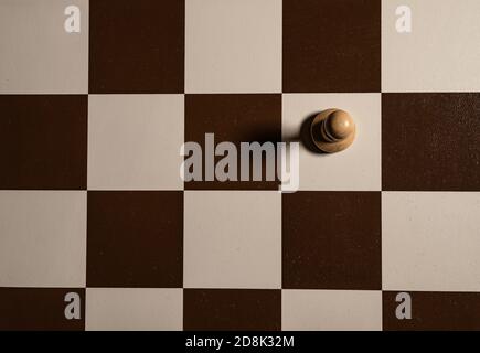 Play wooden chess on a brown checkered table, pawns and rooks, queens and kings, horses table in the dark, stylish for advertising design. Stock Photo