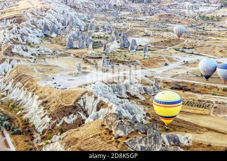 hot air balloons in sky above cliffs in Goreme Cappadocia