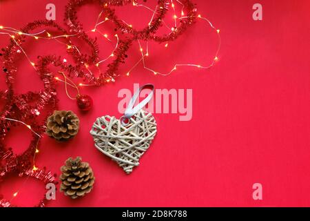 Bright red Christmas flat lay with decorations, garland and wooden decorative heart, family celebrations concept with copy space for your design or te Stock Photo