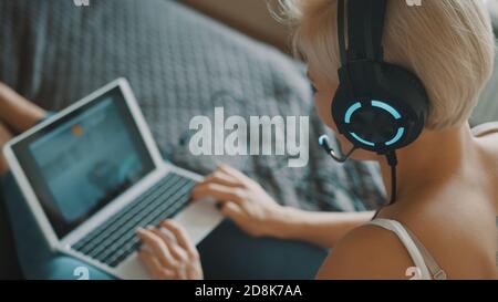 Young caucasian woman using laptop in her bedroom. Freelancer working from the comfort of her home. . High quality photo Stock Photo