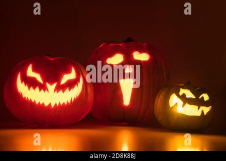 Three carved pumpkins glowing in the dark Stock Photo