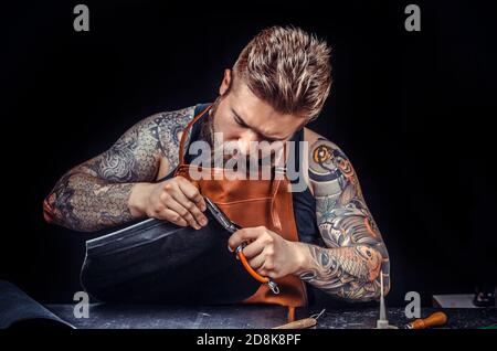 Leather Artist works with leather in the tanner shop Stock Photo