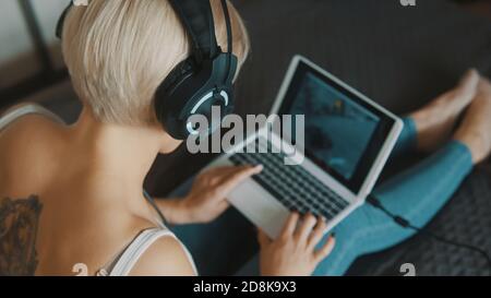 Young woman using laptop in her bedroom. Freelancer working from the comfort of her home. High quality photo Stock Photo