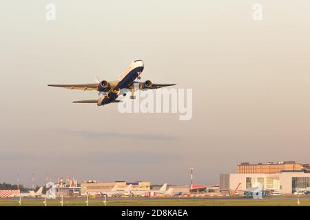 Airplane taking off in summer day, airport on background. Plane fly up at sunset. Vacation, aviation concept Stock Photo