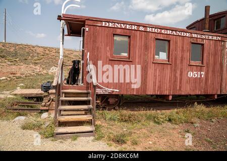 South Park City, Colorado - September 16, 2020: Black labrador retriever dog poses at the old locomotive train on site at the ghost town Stock Photo