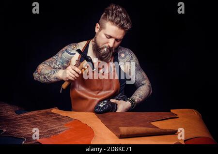 Leather Craftsman working with leather in the workshop Stock Photo