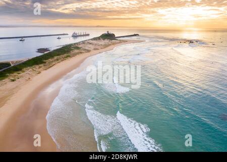 Aerial view of ship leaving port in Newcastle featuring Nobbys Beach. Stock Photo