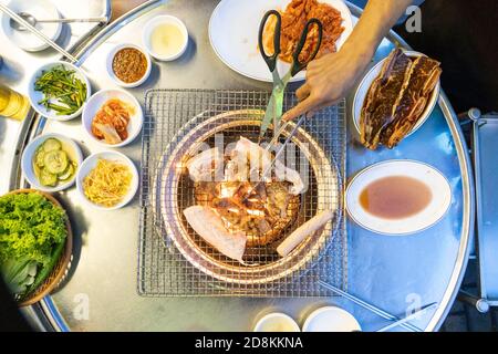 Overhead view of Korean barbecue being grilled, with other dishes Stock Photo