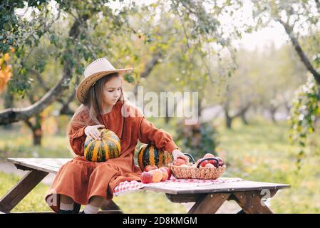 Autumn portrait of child on pumpkin patch on cold autumn day with a lot of pumpkins for halloween or thanksgiving. Child picking pumpkin at farm autum Stock Photo