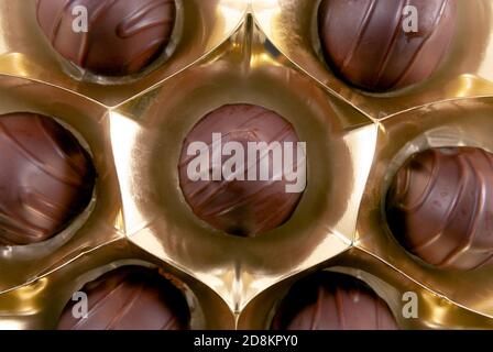 Top view of chocolate sweets in a box of golden color. Close up image Stock Photo